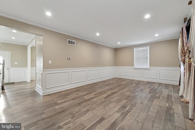 empty room with crown molding and light wood-type flooring