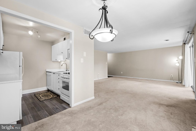 kitchen with white cabinetry, sink, hanging light fixtures, carpet, and white appliances