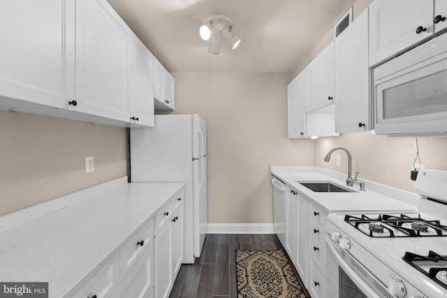 kitchen with white cabinetry, sink, white appliances, and light stone countertops