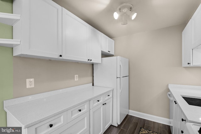 kitchen featuring white appliances, dark hardwood / wood-style floors, light stone countertops, and white cabinets