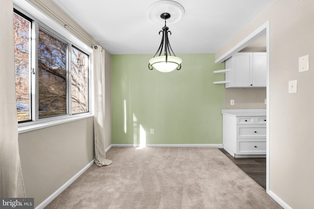 unfurnished dining area featuring light carpet