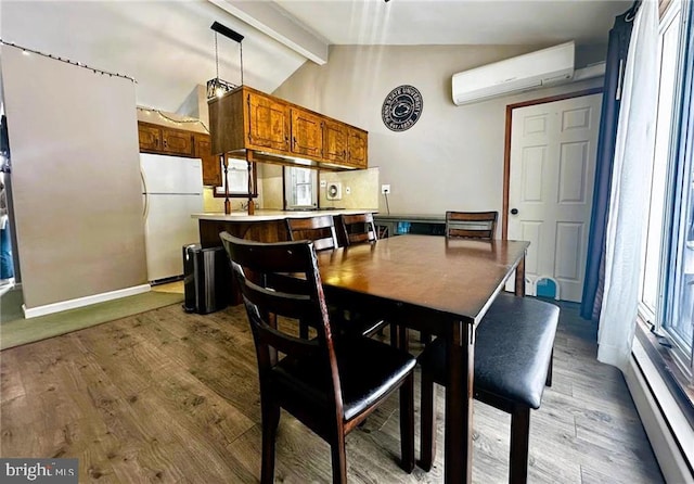 dining room featuring vaulted ceiling with beams, hardwood / wood-style flooring, and an AC wall unit