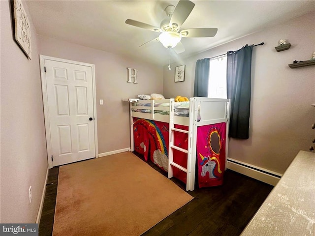 bedroom with a baseboard heating unit, dark wood-type flooring, and ceiling fan