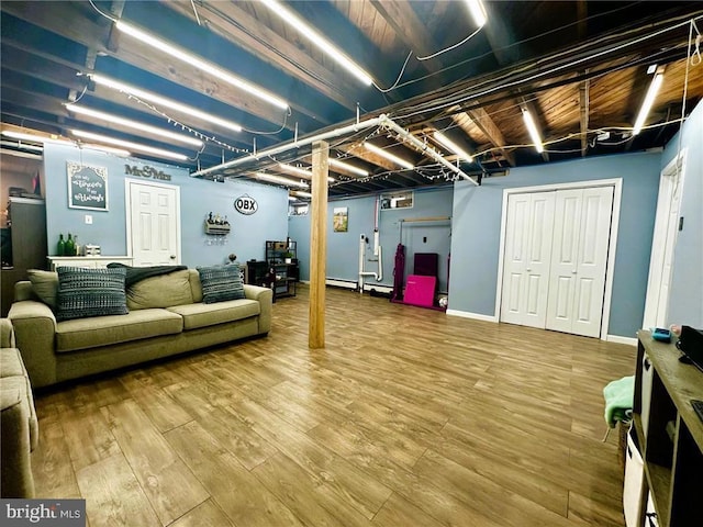 basement with wood-type flooring and a baseboard radiator