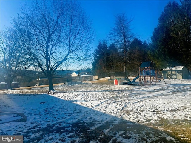 yard covered in snow featuring a playground