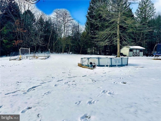 snowy yard featuring a trampoline