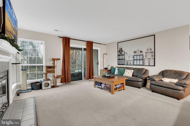 carpeted living room with a tile fireplace