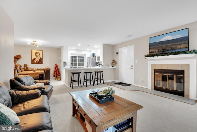 living room featuring light colored carpet and a fireplace