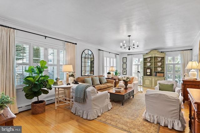 living room featuring a notable chandelier, a wealth of natural light, light hardwood / wood-style floors, and ornamental molding