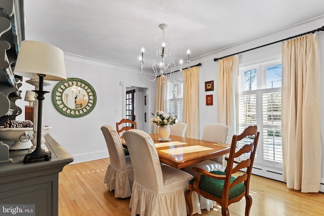 dining room with an inviting chandelier, light hardwood / wood-style flooring, and ornamental molding