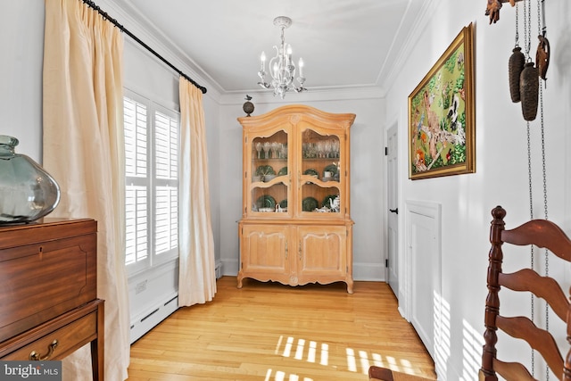 interior space with a baseboard radiator, ornamental molding, light hardwood / wood-style flooring, and a notable chandelier