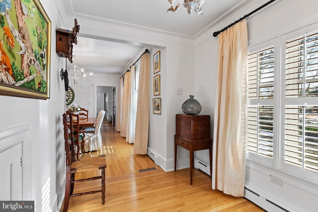 corridor with an inviting chandelier, a healthy amount of sunlight, ornamental molding, and a baseboard heating unit