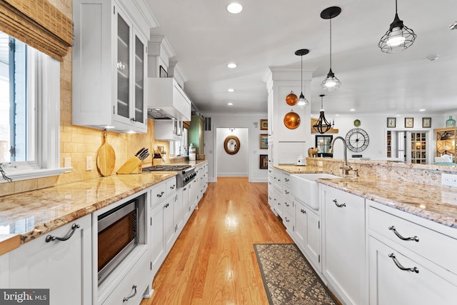 kitchen featuring stainless steel appliances, white cabinetry, sink, and pendant lighting