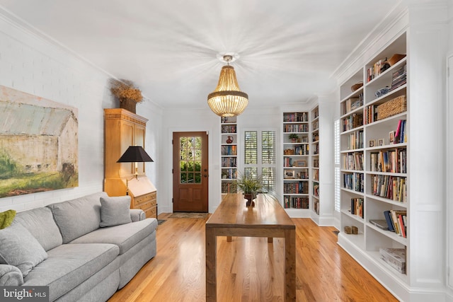 interior space featuring crown molding, an inviting chandelier, and light wood-type flooring