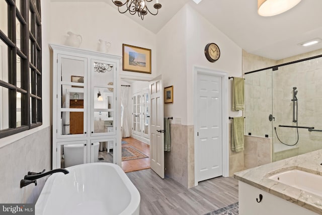 bathroom featuring hardwood / wood-style flooring, vanity, independent shower and bath, and tile walls