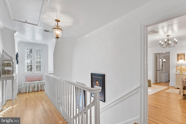 hallway featuring hardwood / wood-style flooring, crown molding, and a chandelier