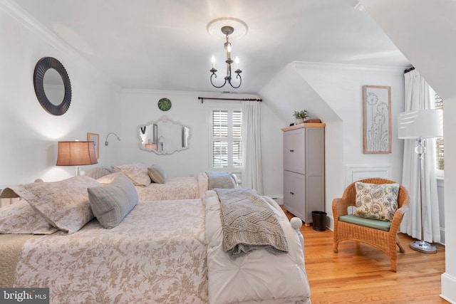 bedroom with a notable chandelier, wood-type flooring, ornamental molding, and vaulted ceiling