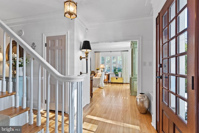 entryway featuring crown molding and light wood-type flooring