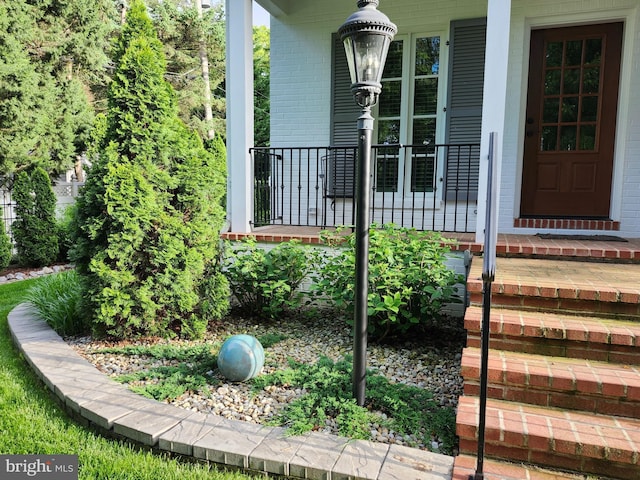 view of exterior entry featuring covered porch