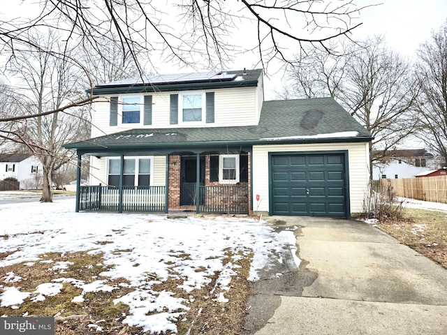 front of property with a porch, a garage, and solar panels