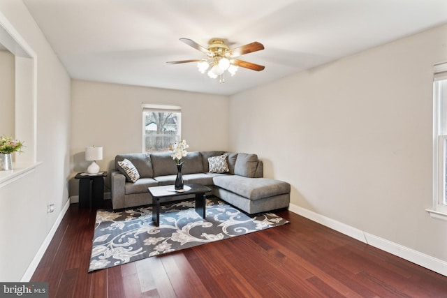 living room with dark wood-type flooring and ceiling fan