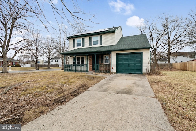 view of front of home featuring a garage, a front yard, and covered porch