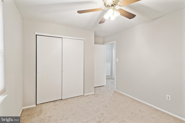 unfurnished bedroom with light carpet, a closet, and ceiling fan