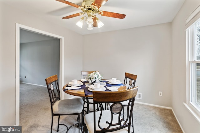 carpeted dining room with ceiling fan