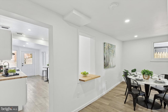 dining area with sink and light hardwood / wood-style floors