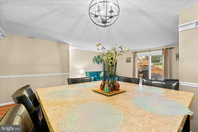 dining area featuring an inviting chandelier and a textured ceiling