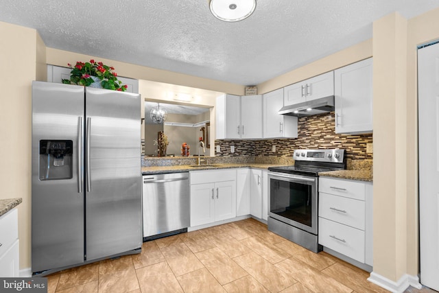 kitchen with tasteful backsplash, white cabinetry, sink, dark stone countertops, and stainless steel appliances