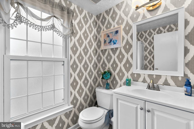 bathroom featuring vanity, toilet, and a textured ceiling