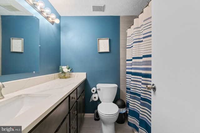 bathroom with toilet, a textured ceiling, vanity, curtained shower, and tile patterned flooring