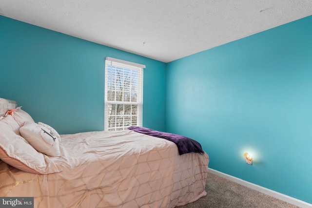 bedroom with a textured ceiling and carpet