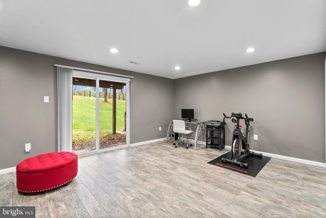 workout room with light hardwood / wood-style flooring