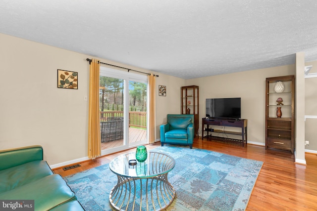 living room with hardwood / wood-style floors and a textured ceiling