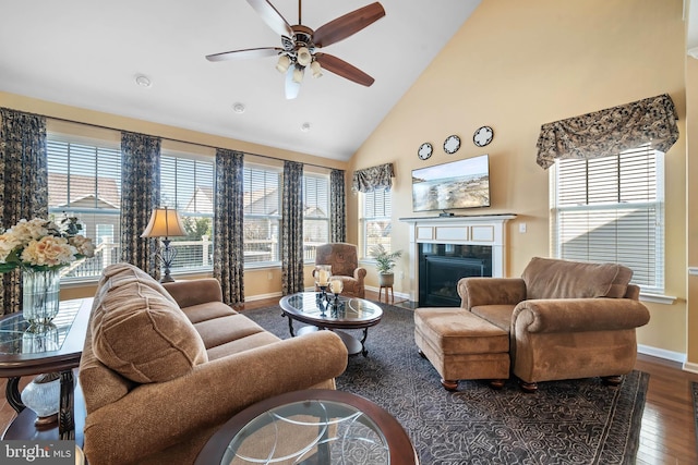 living room featuring dark wood-type flooring, ceiling fan, and high vaulted ceiling