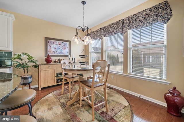 dining space with dark hardwood / wood-style flooring and a notable chandelier