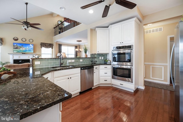 kitchen with white cabinetry, sink, stainless steel appliances, and kitchen peninsula