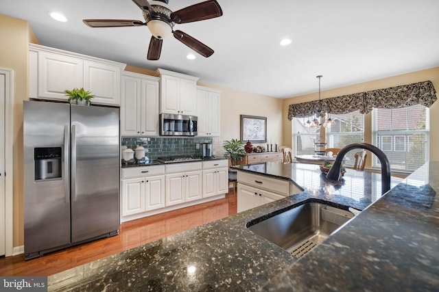 kitchen featuring sink, white cabinetry, tasteful backsplash, stainless steel appliances, and light hardwood / wood-style floors