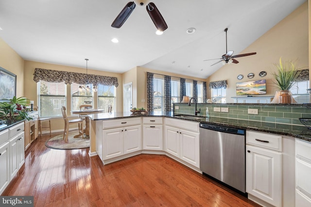 kitchen with ceiling fan with notable chandelier, white cabinetry, sink, stainless steel dishwasher, and light hardwood / wood-style flooring