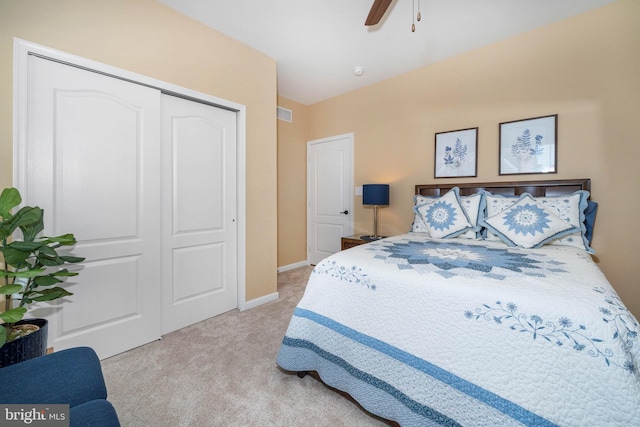 carpeted bedroom featuring ceiling fan and a closet