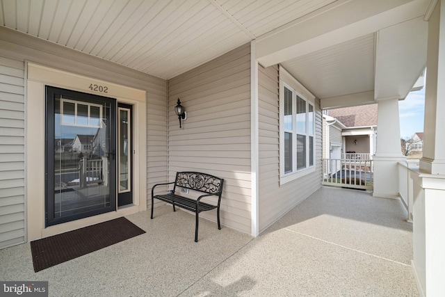 view of exterior entry featuring covered porch