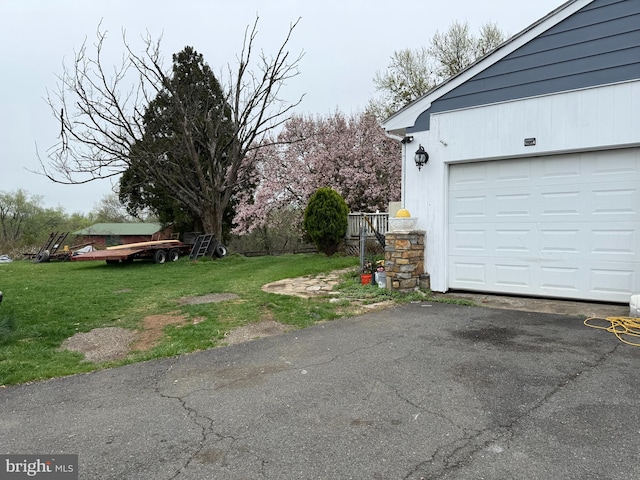 exterior space featuring a yard, a garage, and driveway