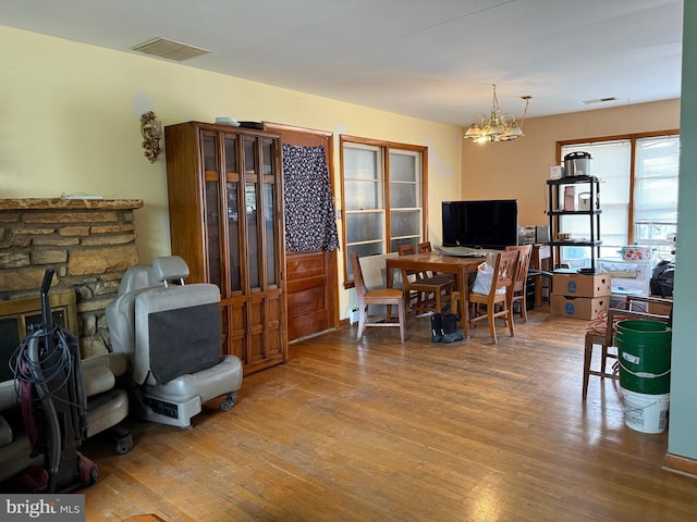 interior space with wood finished floors, a notable chandelier, and visible vents
