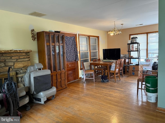 interior space with a chandelier, visible vents, and wood finished floors