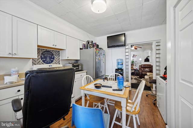 kitchen featuring white cabinets, dark hardwood / wood-style floors, stainless steel fridge, and ceiling fan