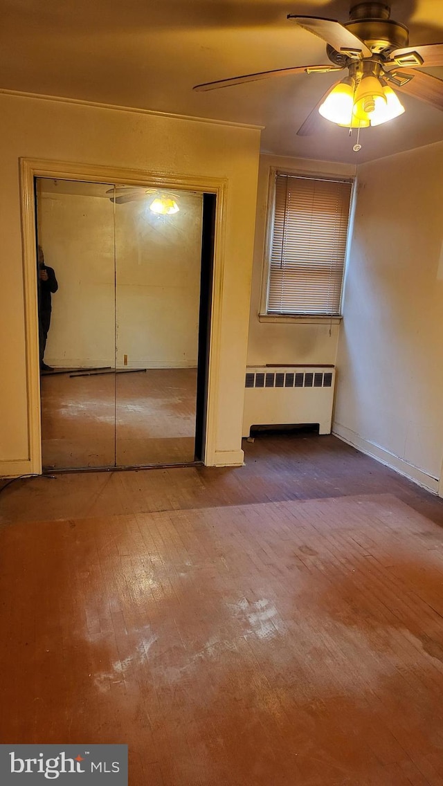 interior space featuring ceiling fan, radiator heating unit, and hardwood / wood-style floors