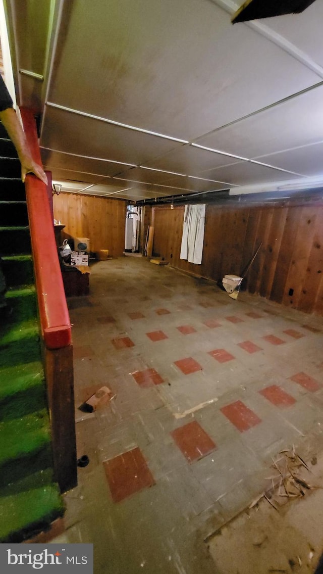 basement featuring wooden walls