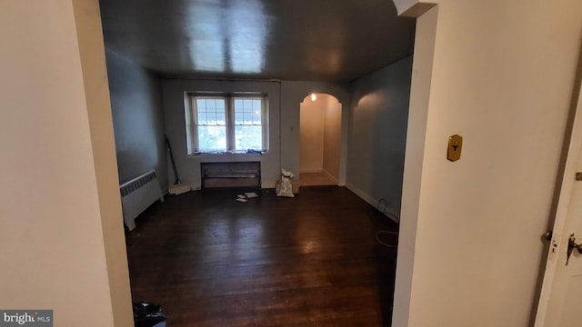 unfurnished room featuring dark hardwood / wood-style flooring and radiator